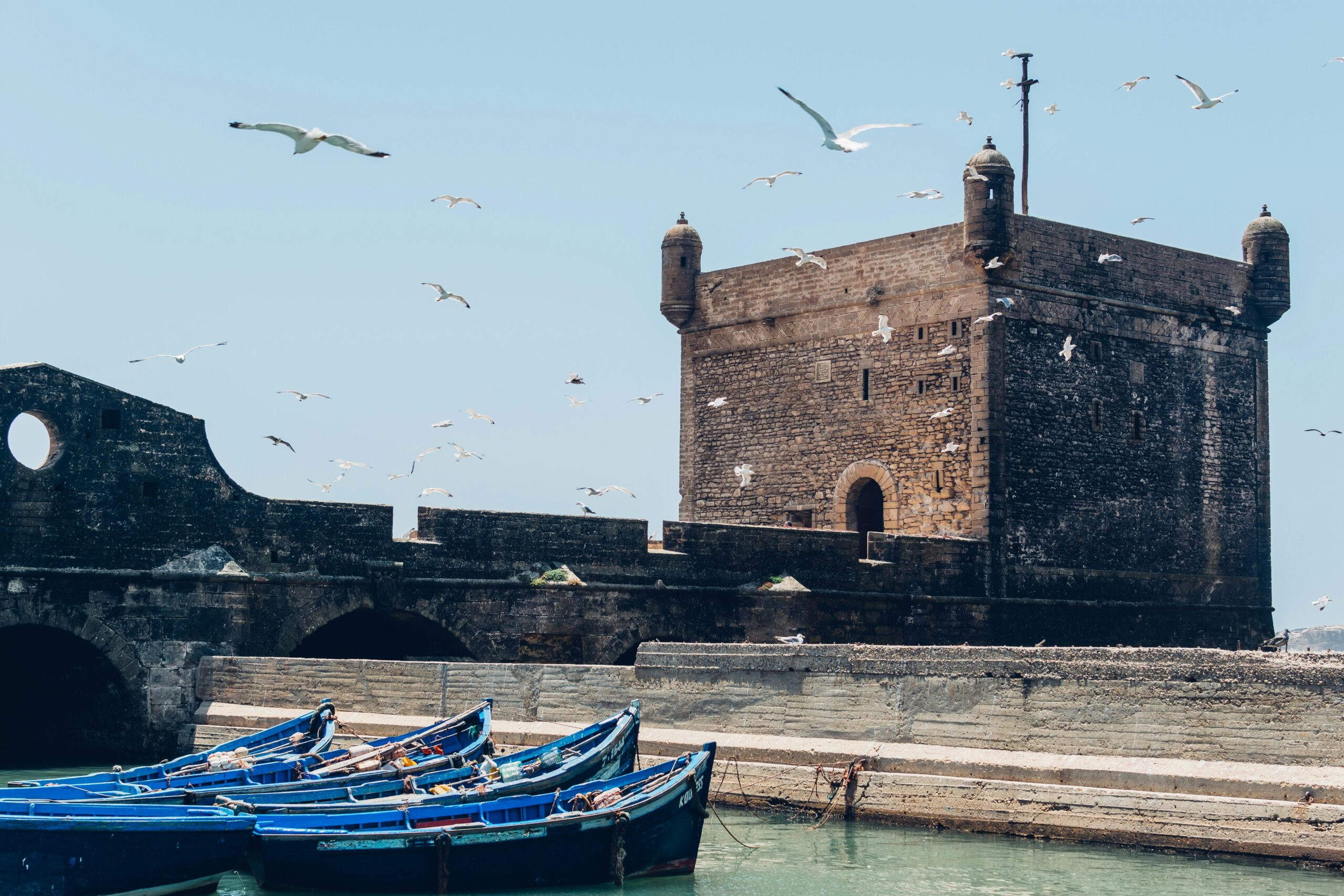 Blue and white harbour of Essaouira Morocco with fishing boats and fortified ramparts