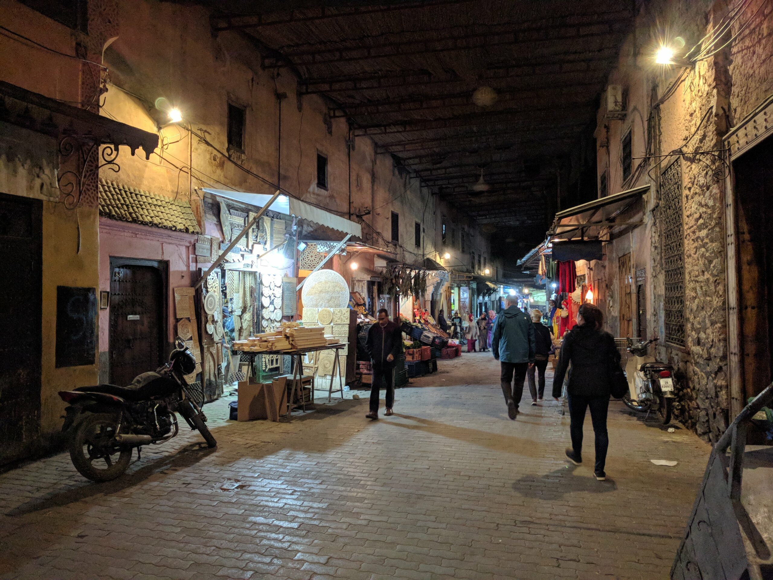 Marrakech medina at night with lit lanterns and bustling streets